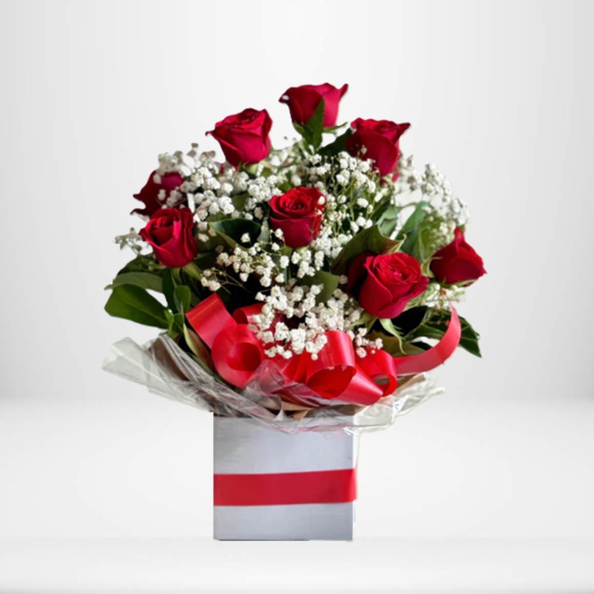 Arrangement of red roses with baby's breath in a white box with a red ribbon