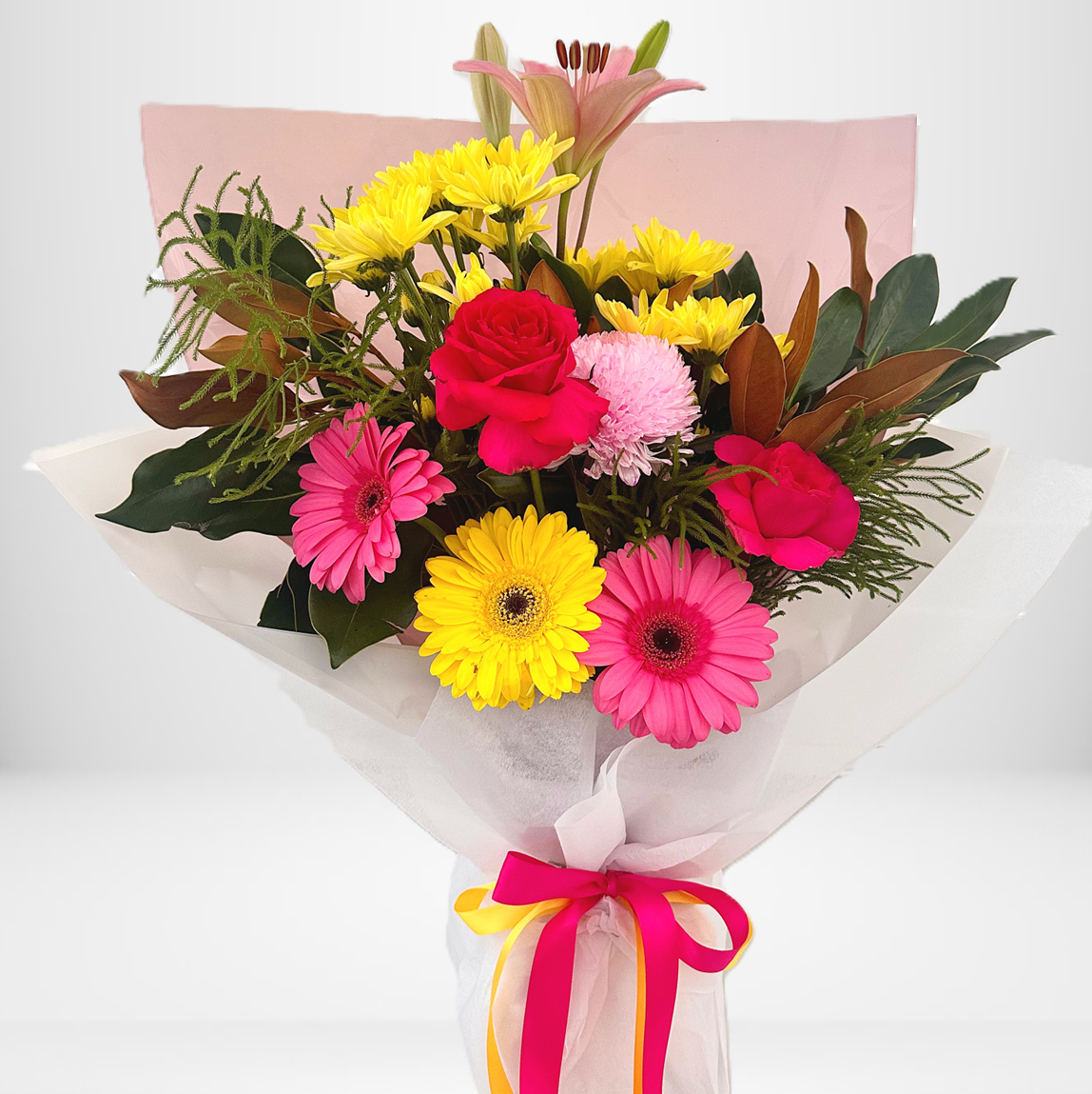Bright pink and yellow flower bouquet with gerberas, roses and lilies wrapped in blush paper by Bella Bloom Bar, Hills District Florist.