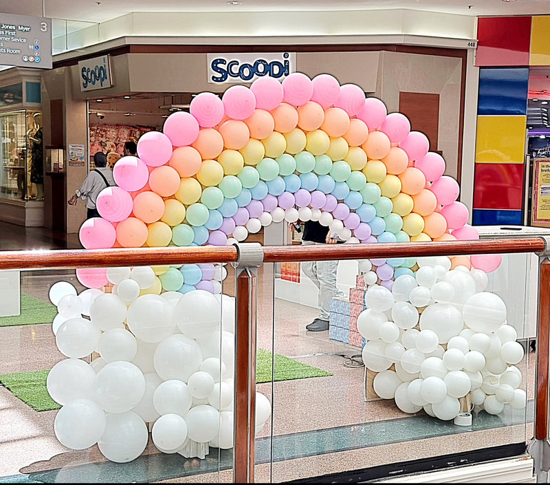 Pastel rainbow balloon arch with white balloon clouds at Castle Towers Shopping Centre Sydney